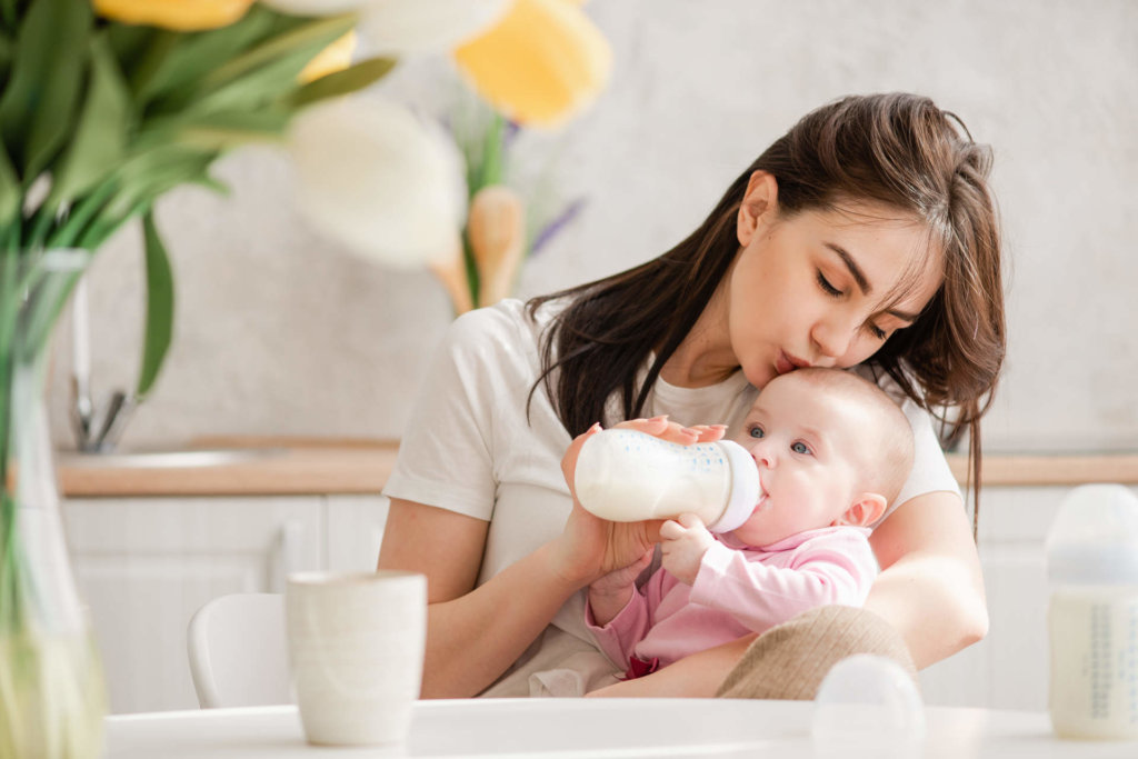 Mother feeding her baby with bottle.